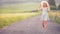 Young woman in hat walking on field road. Summer romantic image