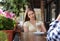 Young woman having boring date with guy in outdoor cafe