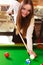 Young woman having fun with billiard.