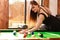 Young woman having fun with billiard.