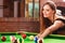 Young woman having fun with billiard.