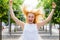 Young woman having fun in park, jumps and shouts