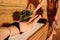 young woman having a russian sauna procedure with bath brooms from oak leaves