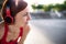 Young woman with headphones resting after doing exercise outdoors in city.