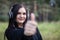 Young woman in headphones shows class gesture, thumb up