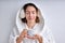 Young woman In headset drinking tea or coffee in the morning, wearing bathrobe