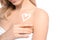 Young woman with heart made of cream on her shoulder against white background, closeup