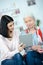 Young woman helping grandmother using tablet