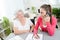 Young woman helping an old senior woman doing paperwork and administrative procedures with laptop computer at home