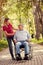 Young woman with her disabled smiling father in wheelchair