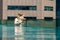 Young woman with her little daughter in the pool on the roof of a skyscraper in a metropolis look overboard