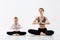 Young woman with her little daughter practising yoga together