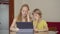 A young woman and her little son sit a home during quarantine and study in the internet school using a tablet. Corona