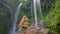 Young woman and her little son tourists visit the biggest waterfall on the Bali island - the Sekumpul waterfall. Travel