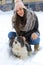Young woman with her shih-tzu dog in snow