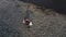 Young woman with her son collects plastic garbage in a garbage bag on the river. Empty used dirty plastic bottles