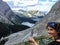 A young woman hiker admiring the view from the side of the mountain. Down below is the Rockies and upper Kananaskis lake