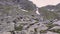 A young woman hiker climbs mountains and photographs landscapes on camera. Transfagarasan, Carpathian mountains in Romania