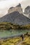 Young woman hiker on the trail in Torres del Paine National Park, Chile. Trekker watching the mountain scenery at the lake.