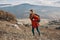 young woman hiker traveling in the mountains on nature and landscape backpack jacket jeans boots