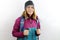 Young woman hiker with wool cap and backpack smiling happy. Standing with smile on face doing trekking using hiking stick