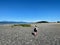 A young woman hiking alone at low tide between Denman Island and Jáji7em and Kw’ulh Marine Park