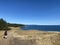 A young woman hiking along a beautiful coastline trail on Hornby Island.