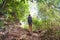 Young woman with hiking bag on a trekking trail in tropical rain