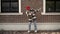 Young woman hip hop street dance on background of brick building, gimbal shot