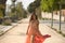 Young woman, Hispanic, beautiful, brunette, with an elegant salmon-colored dress, posing while the wind lifts her dress walking