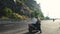 Young woman hitchhiker standing on the road