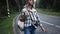 Young woman hitchhiking on the forest road