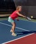 Young woman hits a pickleball with a backhand volley