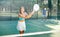 Young woman hitting two handed backhand during paddle tennis match
