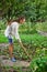 Young woman with hoe working in the garden bed