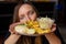 Young woman hold in hands plate with fries, chicken fillet and vegetable salad and stare with hungry eyes. Serving of