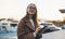 Young woman hold sellphone in evening port Barcelona. Girl in glasses using smartphone technology. Digital business communication