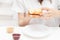 A young woman is holding an American sandwich with jam and peanut butter, preparing to eat it for breakfast in the morning at home