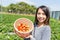 Young Woman holding basket of strawberry in the farm