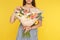 Young woman holding beautiful flower bouquet on yellow background