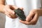 Young woman holding beautiful labradorite gemstone on beige background