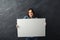 Young woman holding blank white banner