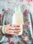 Young woman holding bottle of dairy-free almond milk in hand