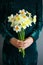 Young woman holding bouquet narcissus