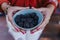 young woman holding a bowl of blackberries. preparing a healthy recipe of diverse fruits, watermelon, orange and blackberries.