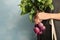 Young woman holding bunch of fresh beets on blue background, closeup