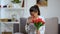 Young woman holding bunch of tulips and sneezing, seasonal allergy, health