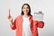 Young woman holding calendar with menstrual cycle days on light background