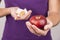 Young woman holding candy and apple