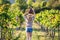 Young woman holding carboy with wine in vineyard